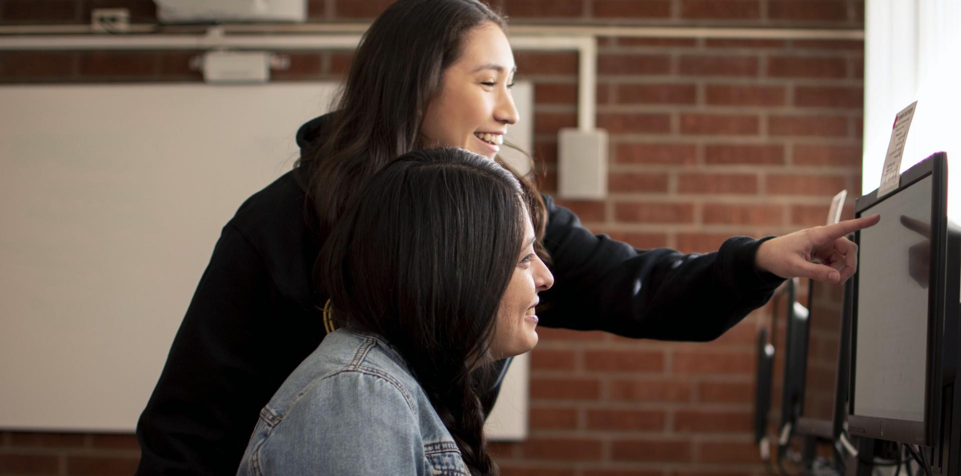 Two students looking at a computer.